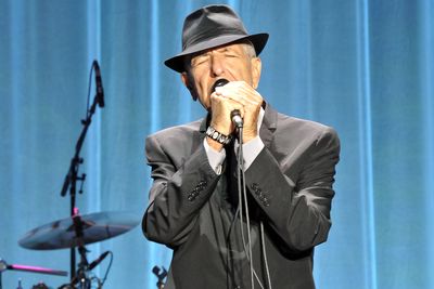 Leonard Cohen 2013 mit Hut und Mikrofon auf der Bühne